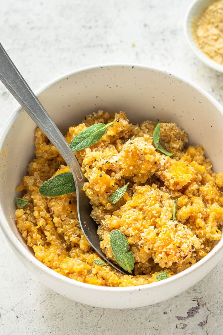 A bowl of butternut squash quinoa risotto garnished with sage.