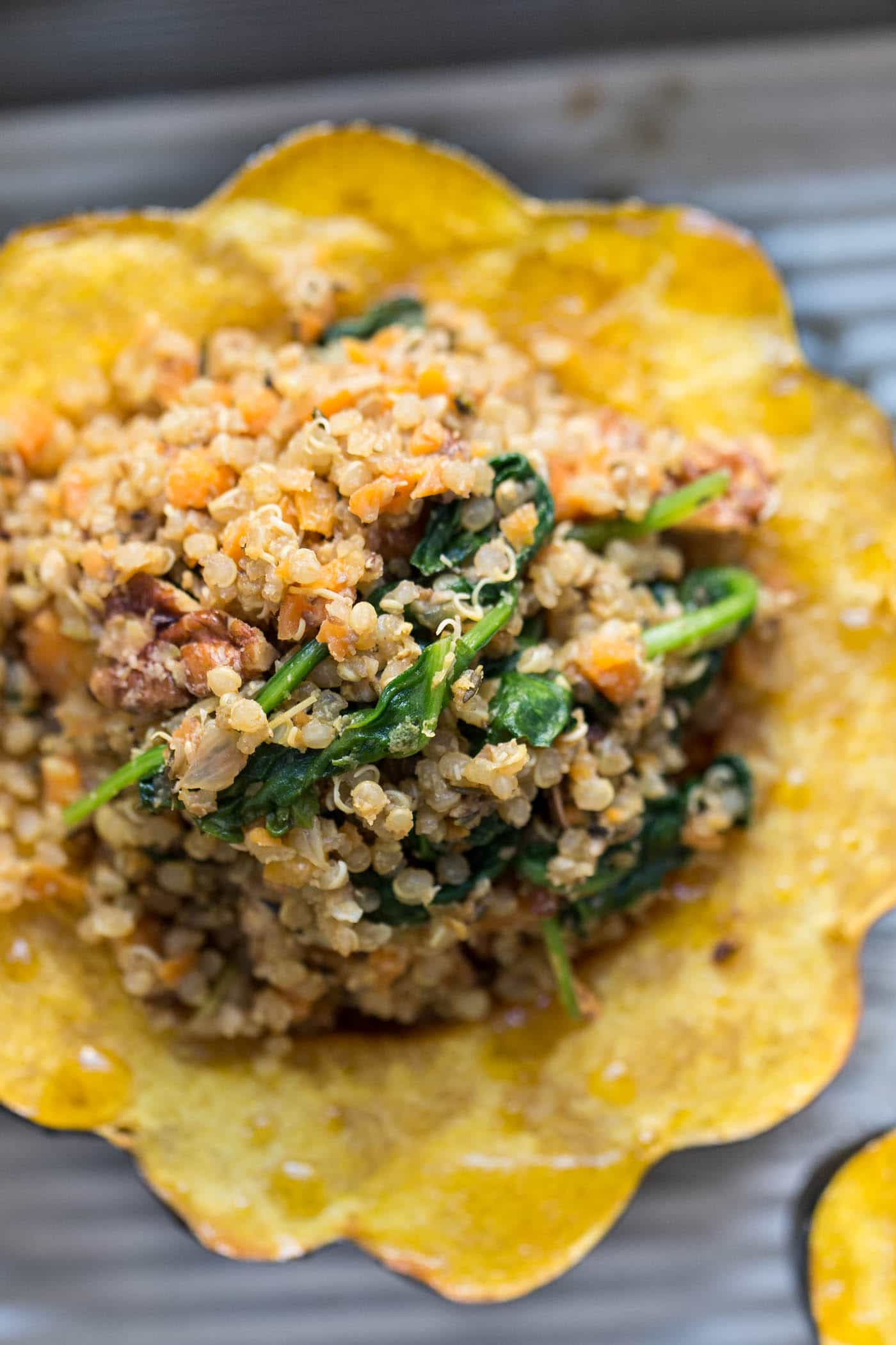 Close up of a mushroom stuffed acorn squash, with lots of wilted spinach in it