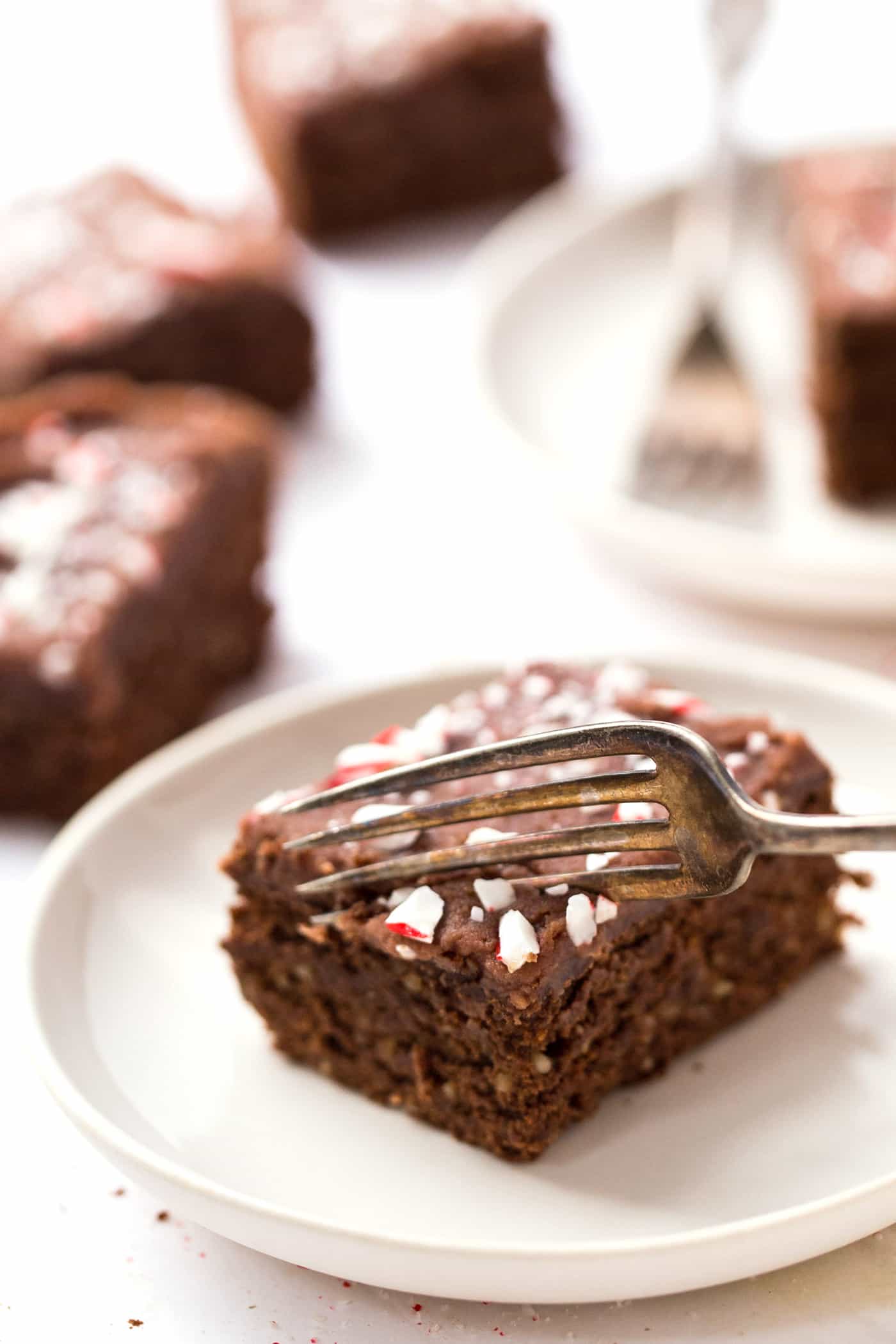 High Protein Chickpea Brownies topped with a chocolate coconut butter icing and crushed peppermint candies! A HEALTHY holiday treat!