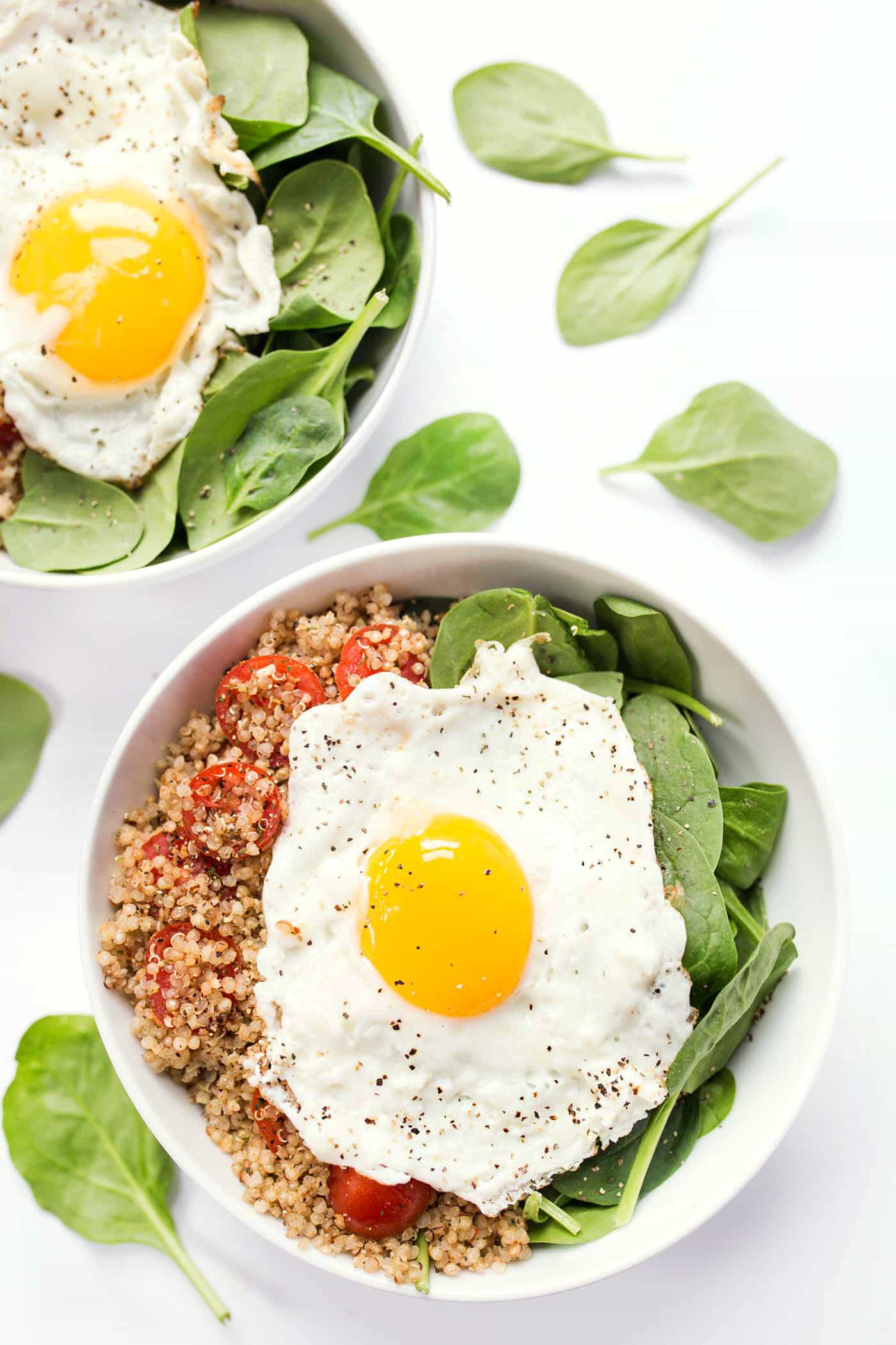 Savory Breakfast Quinoa Bowls with spinach, tomatoes and fried eggs on top!