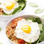 Savory Breakfast Quinoa Bowls with spinach, tomatoes and fried eggs on top!