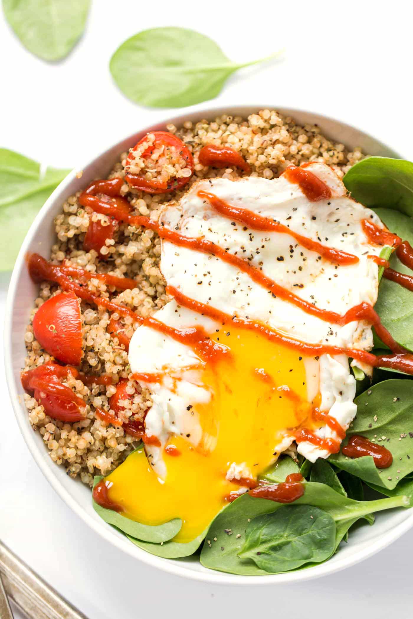 These SAVORY Quinoa Breakfast Bowls take just 5 minutes to make and are packed with healthy ingredients >> spinach, tomatoes and fried eggs make this a protein-packed breakfast!