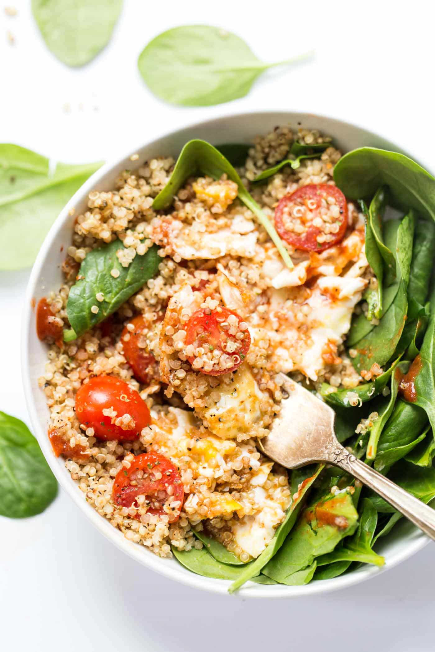 These SAVORY Quinoa Breakfast Bowls take just 5 minutes to make and are packed with healthy ingredients >> spinach, tomatoes and fried eggs make this a protein-packed breakfast!