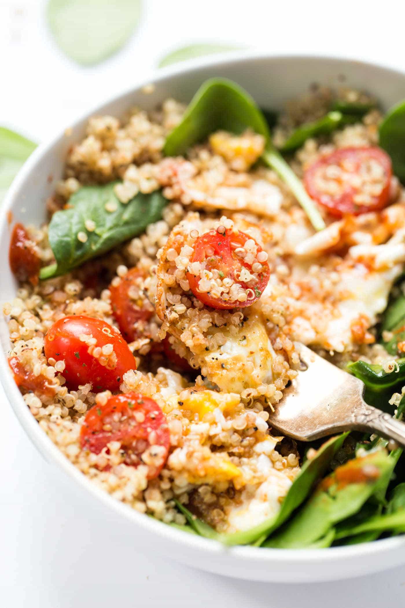 These SAVORY Quinoa Breakfast Bowls take just 5 minutes to make and are packed with healthy ingredients >> spinach, tomatoes and fried eggs make this a protein-packed breakfast!