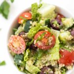 Mediterranean Quinoa Salad with chopped romaine, cherry tomatoes, cucumbers, olives and a creamy herbed tahini dressing!