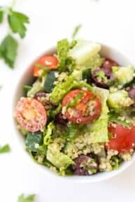 Mediterranean Quinoa Salad with chopped romaine, cherry tomatoes, cucumbers, olives and a creamy herbed tahini dressing!