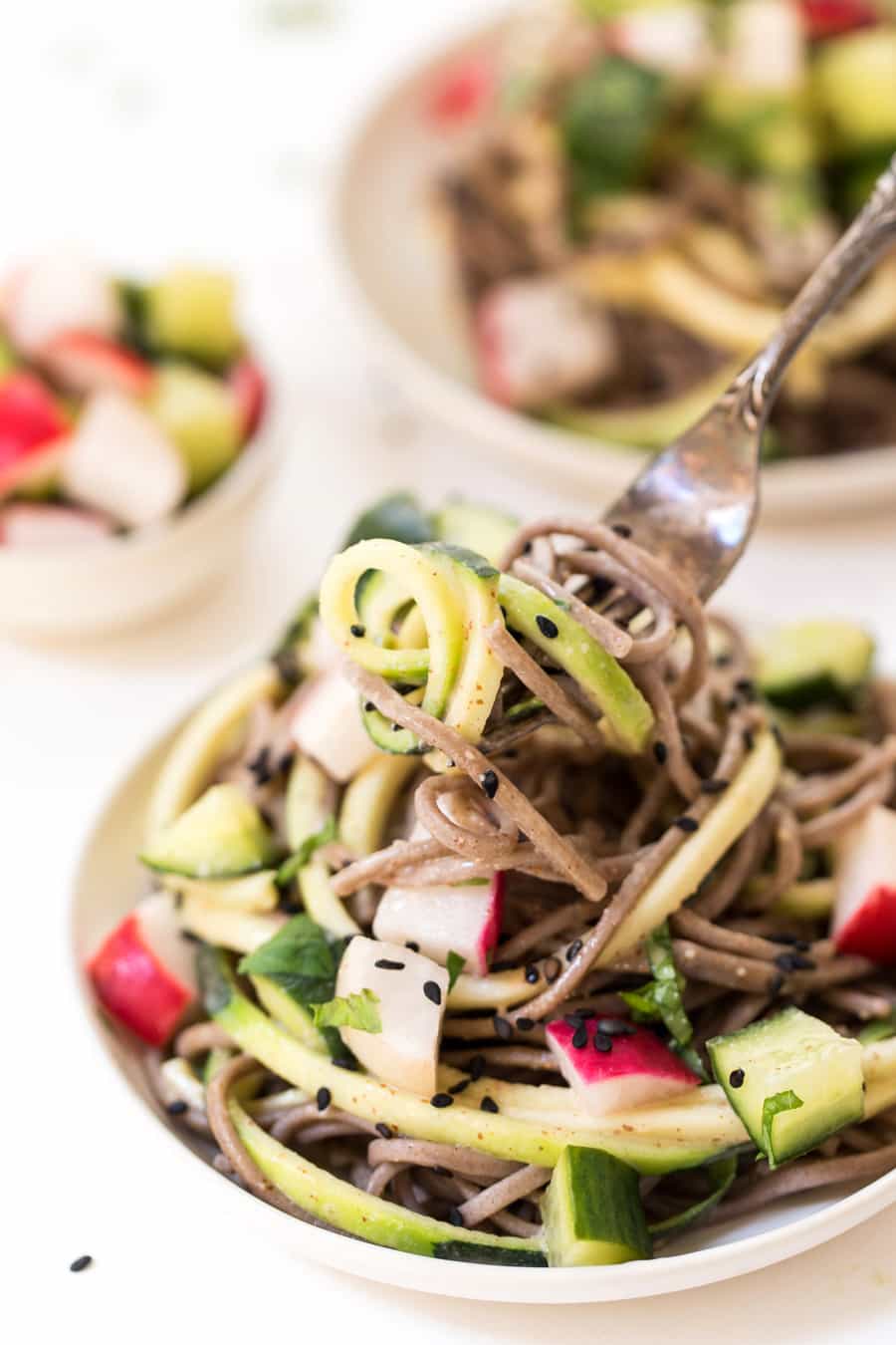 Fork lifting sesame soba noodles from plate
