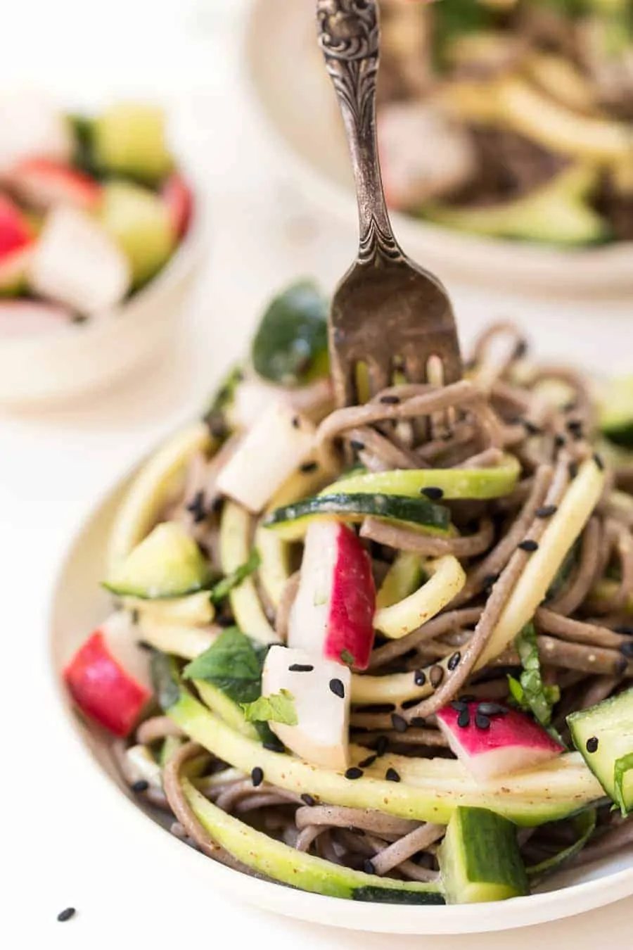 Sesame soba noodles are a light, healthy meal with a creamy sweet-and-tangy almond butter sauce and crunchy pickled veggies. So delicious! Fork twirling sesame soba noodles on plate