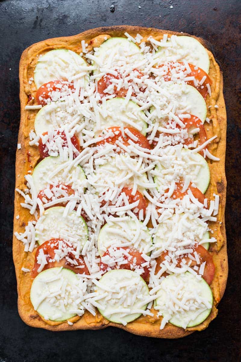 Summery Quinoa Pizza topped with hummus, tomato and zucchini! It's simple, light and SO flavorful!