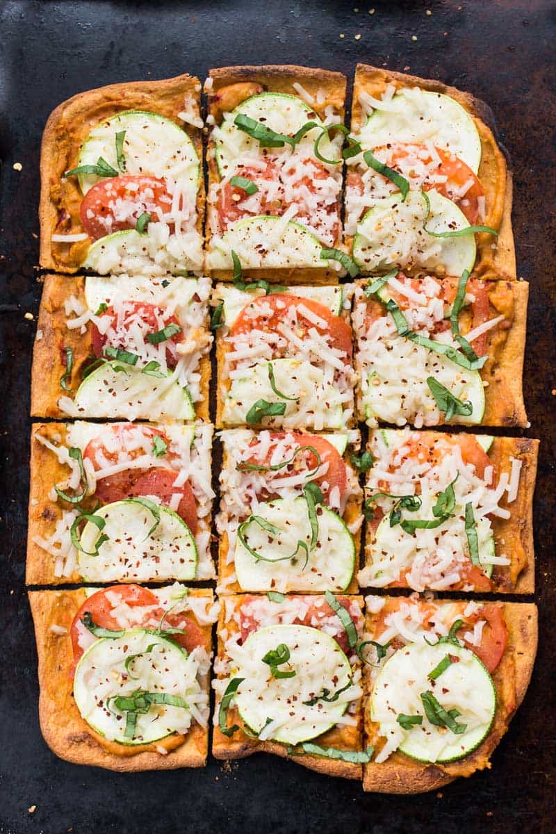 Summery Quinoa Pizza topped with hummus, tomato and zucchini! It's simple, light and SO flavorful!