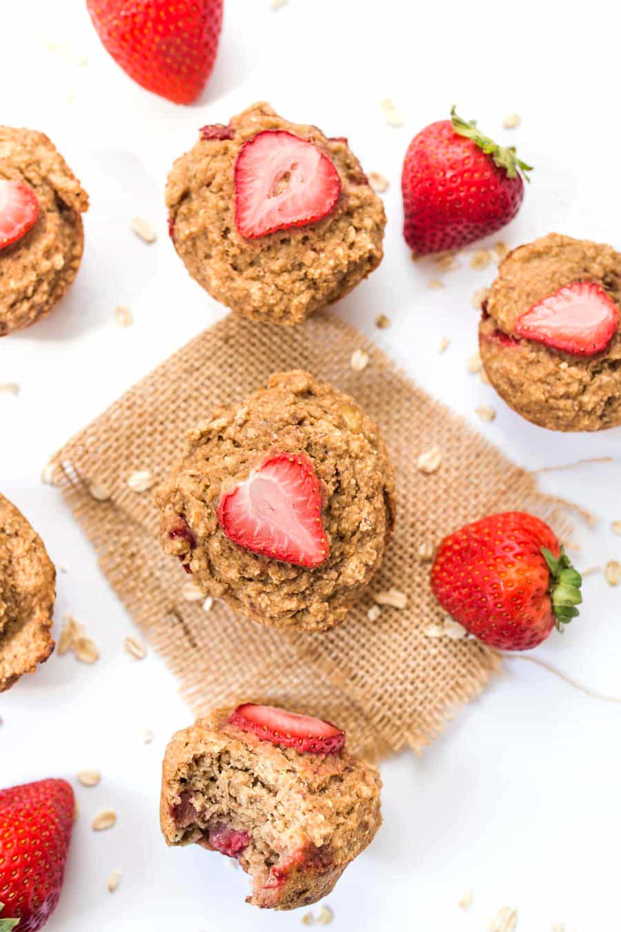Healthy banana oatmeal muffins with strawberries on table