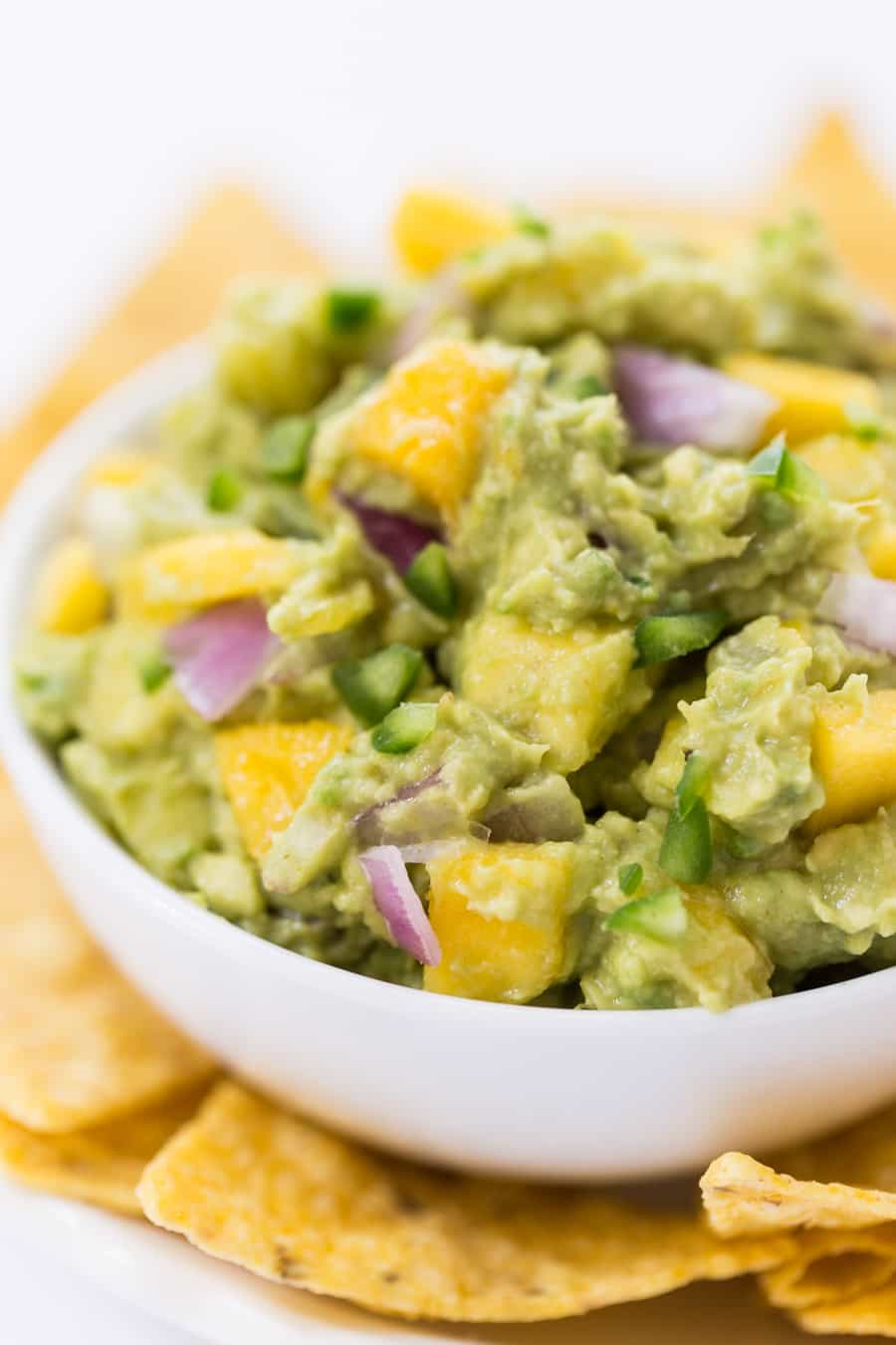 This SPICY MANGO GUACAMOLE recipe is a quick and easy spread that goes with everything. Use it on top of burgers, dip with chips or spread it on some toast!