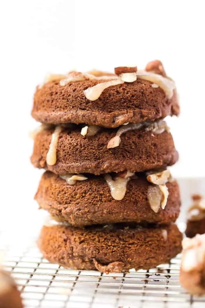 Gluten-Free & Vegan Pumpkin Donuts -- topped with a coconut butter icing and chopped hazelnuts!