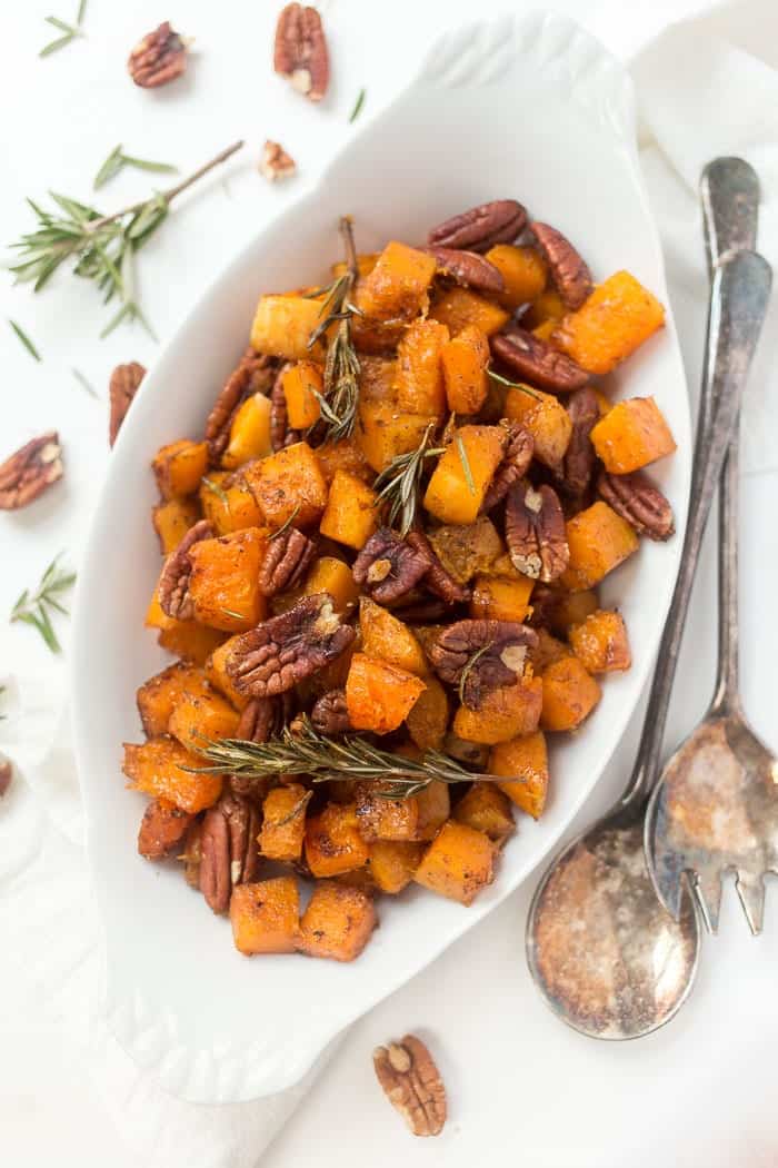 With tender squash, toasty pecans and maple glaze, this roasted butternut squash is a perfect holiday side, but easy enough for a weeknight! Overhead view of maple roasted butternut squash with pecans and rosemary