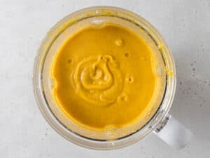 Overhead view of pureed acorn squash soup in a blender.