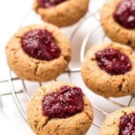 These HEALTHY & Gluten-Free Raspberry Thumbprint Cookies are made with a cashew butter base and topped with homemade raspberry chia seed jam! [VEGAN]