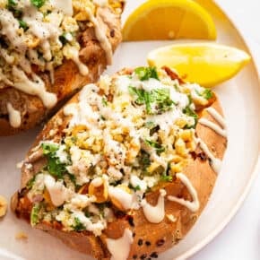 Two stuffed sweet potatoes with quinoa, kale, and tahini.