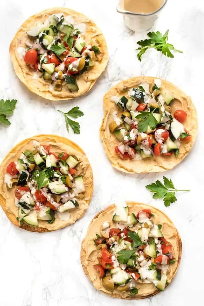 mediterranean tostadas topped with cucumber-tomato salad