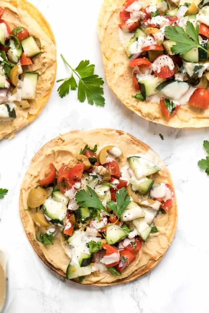 mediterranean tostadas topped with cucumber-tomato salad