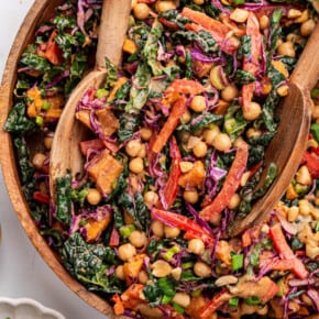 Overhead view of kale sweet potato salad in serving bowl with serving spoons