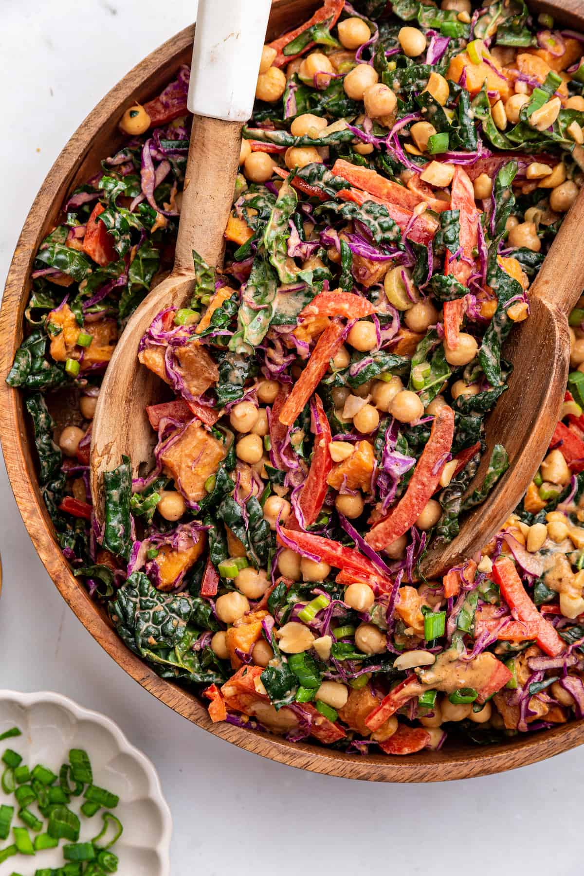 Overhead view of kale sweet potato salad in serving bowl with serving spoons