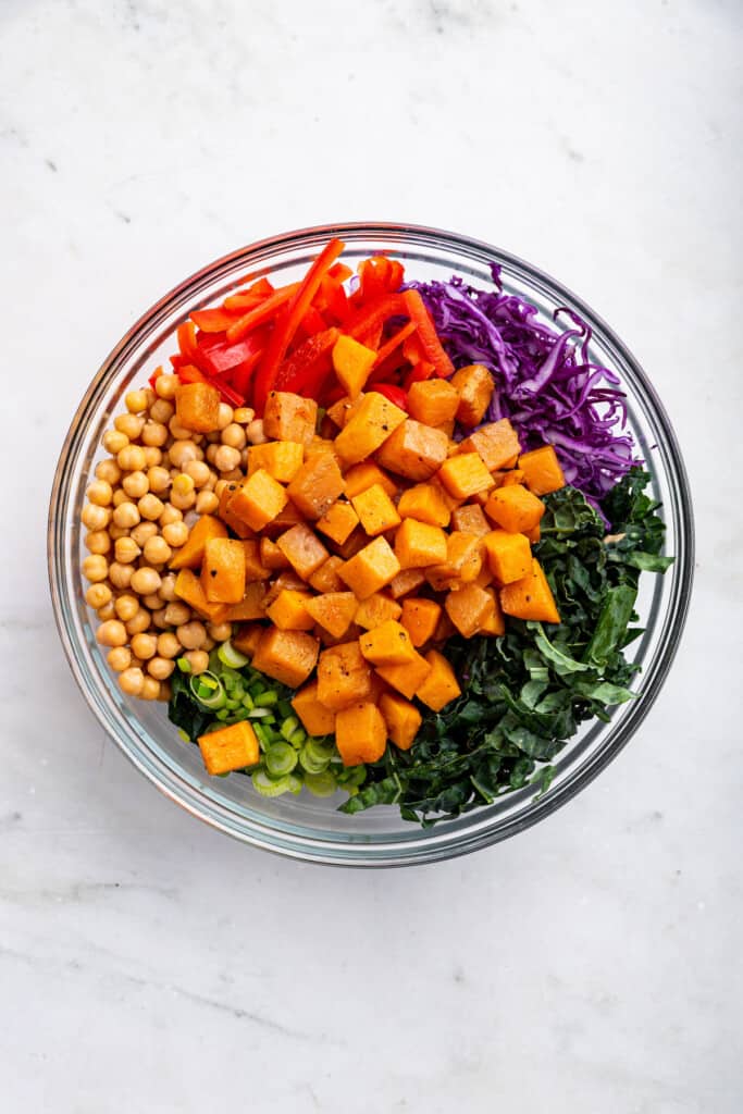 Overhead view of ingredients for kale sweet potato salad in mixing bowl