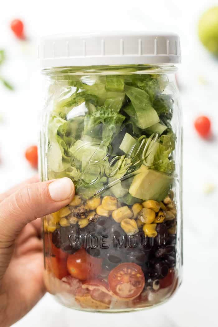 vegetarian taco mason jar salads with black beans, corn, tomatoes and a chili dressing