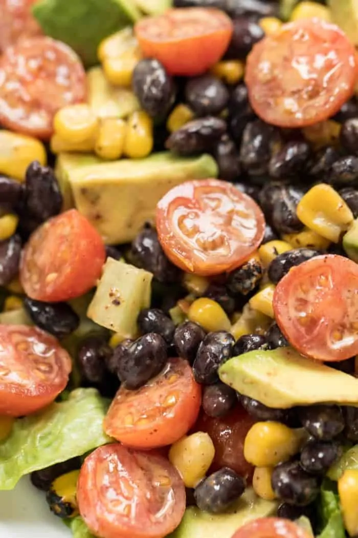 healthy taco mason jar salad with black beans, tomatoes and chili dressing