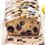 Slices of glazed blueberry banana bread topped with lemon zest