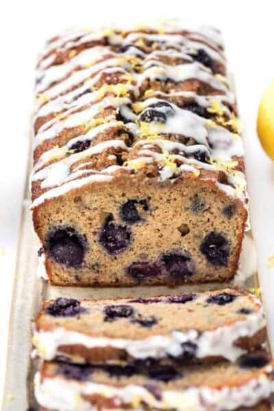 Slices of glazed blueberry banana bread topped with lemon zest