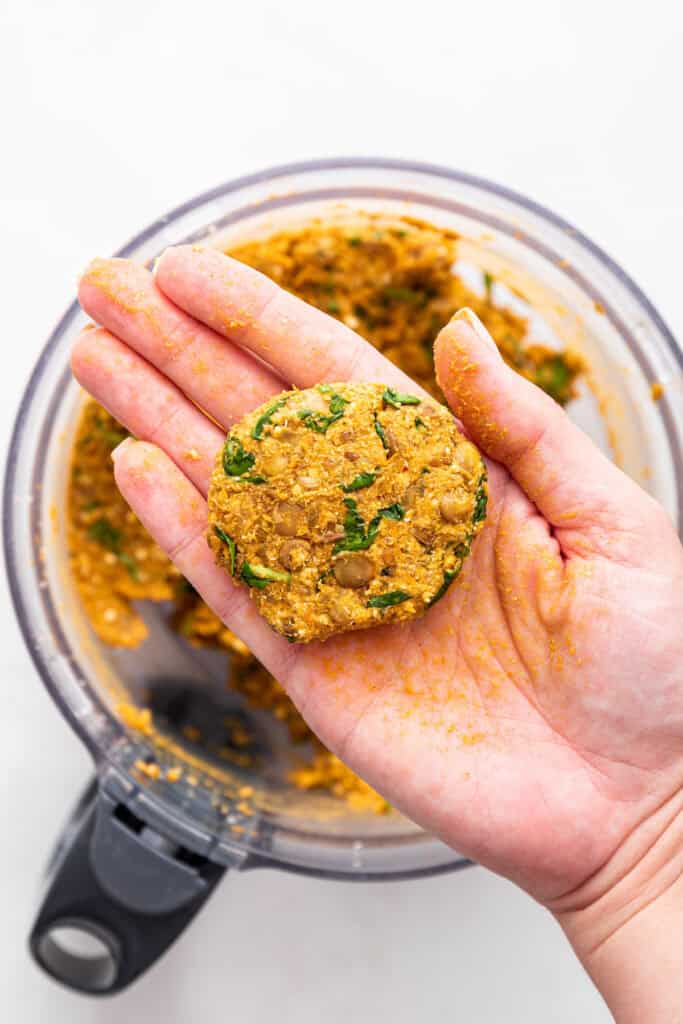 Hand holding lentil patty after shaping it