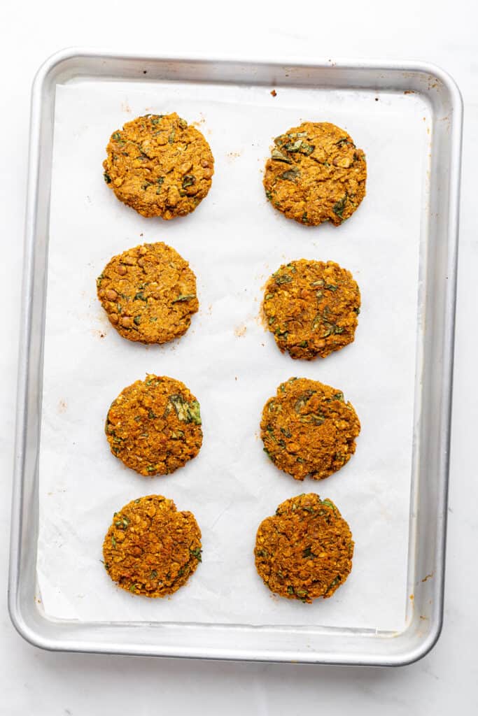 Overhead view of lentil patties on parchment-lined baking sheet