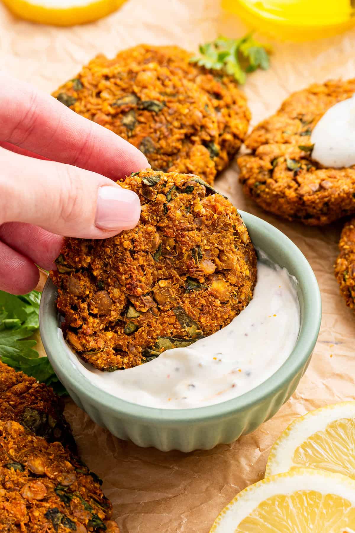Dipping lentil patty into sauce
