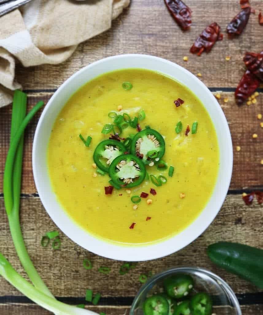 turmeric potato soup recipe in a white bowl with jalapenos on top