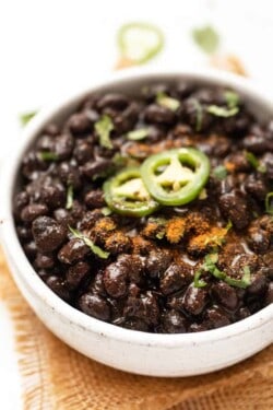 Bowl of Instant Pot black beans with jalapeño slices on top