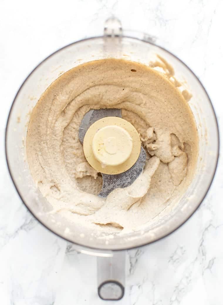 Overhead view of vegan cashew cheesecake filling inside a food processor.