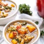 A bowl of Tuscan kale white bean soup with a second bowl in the background.