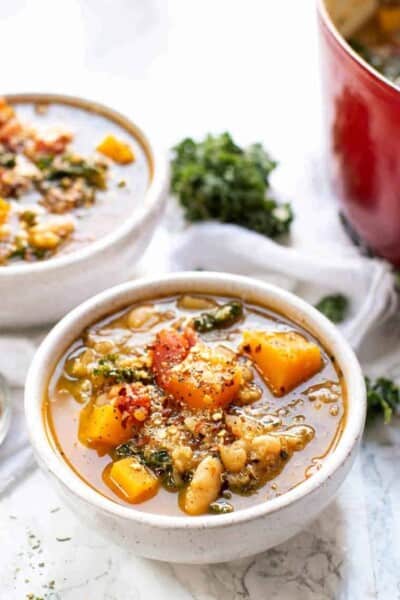 A bowl of Tuscan kale white bean soup with a second bowl in the background.