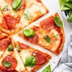 Pepperoni almond flour pizza sliced on board