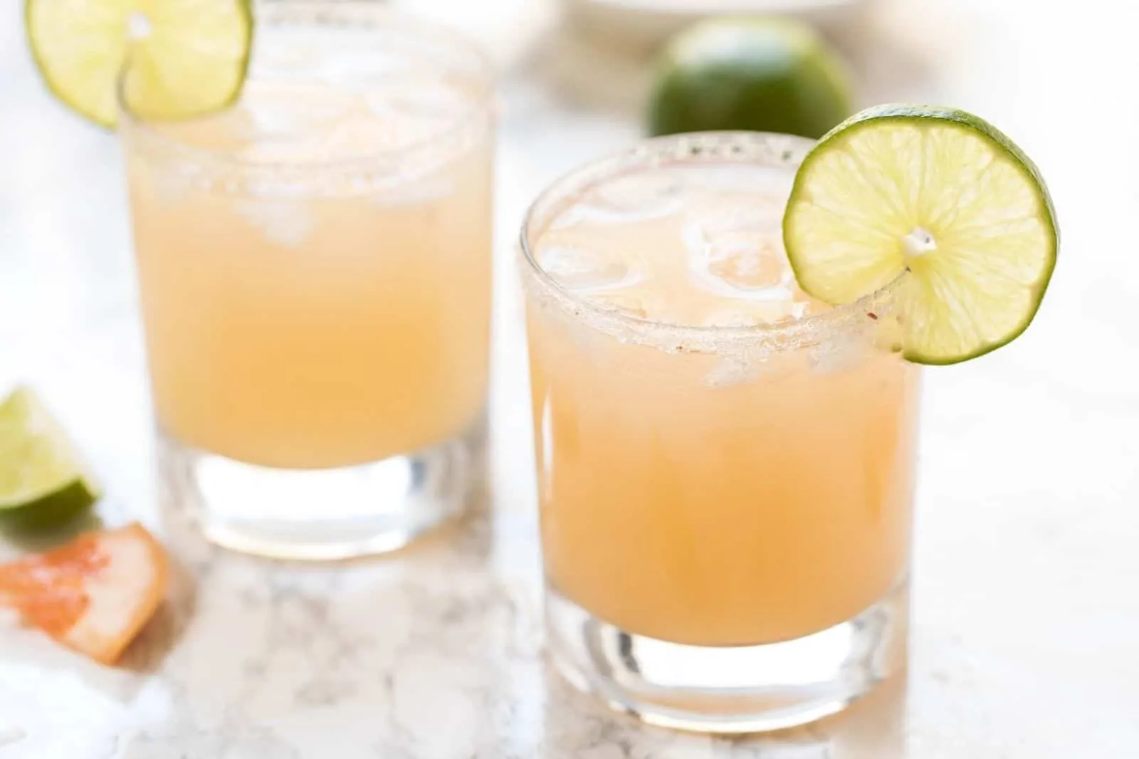 Two grapefruit margaritas in glasses with lime slices