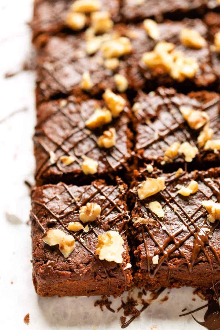 These fudgy almond butter brownies are a unique twist on the traditional recipe, using healthier ingredients. Vegan and gluten-free too! Almond butter brownies cut into squares