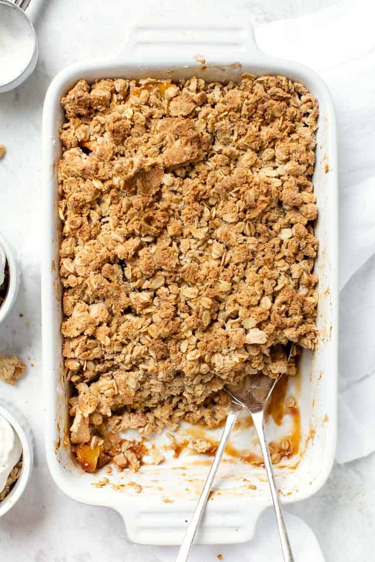 Peach crisp with a scoop taken out.