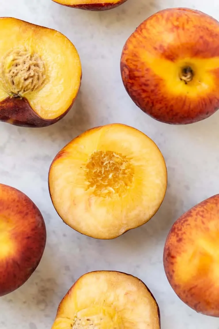 Overhead view of peaches, some whole and some cut in half