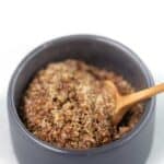 Flaxseed and water in a bowl with a wooden spoon.
