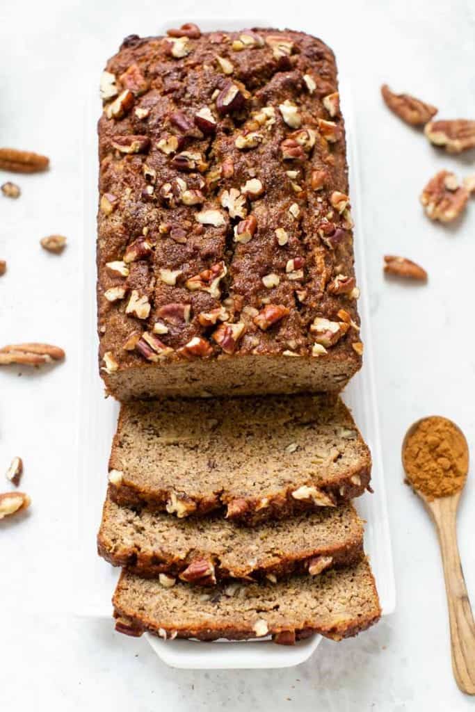 This gluten-free apple banana bread recipe is made with high-protein almond and quinoa flours, apples, and cinnamon for a cozy fall treat! Overhead view of an apple banana bread loaf cut into slices.