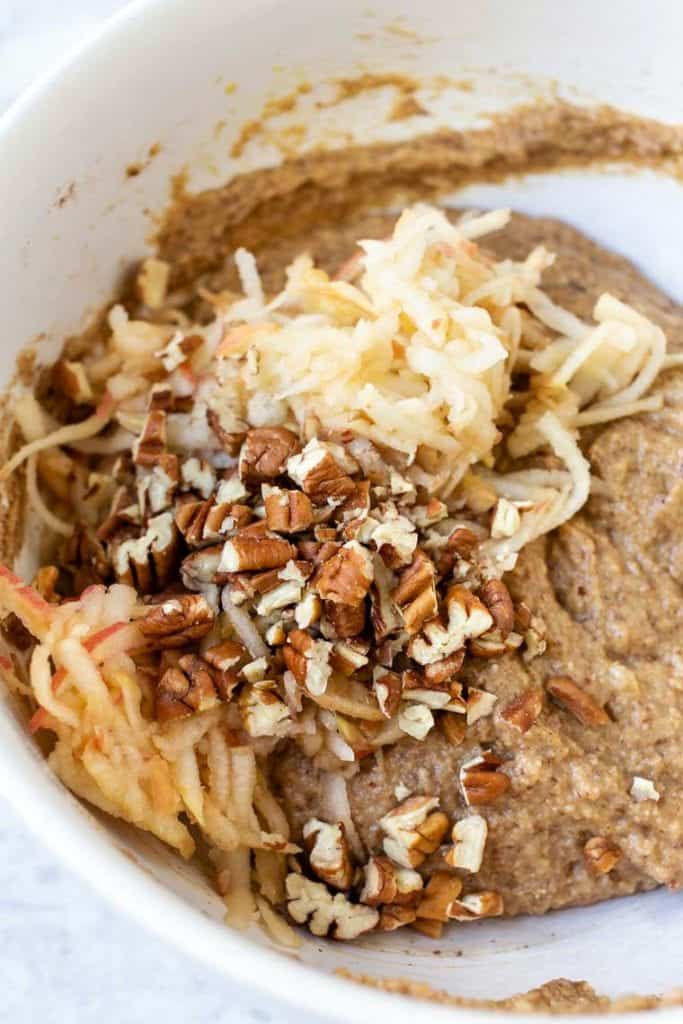 This gluten-free apple banana bread recipe is made with high-protein almond and quinoa flours, apples, and cinnamon for a cozy fall treat! Combining the ingredients for apple banana bread in a mixing bowl.