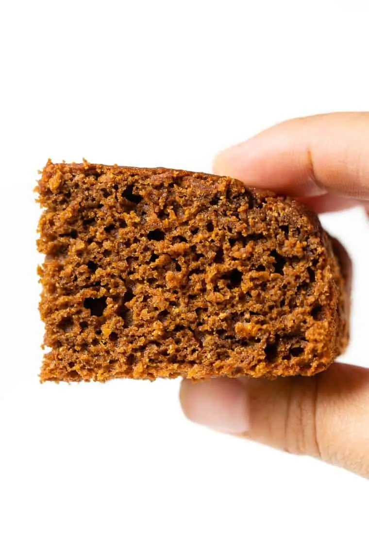 Hand holding slice of Gluten-Free Gingerbread Cake