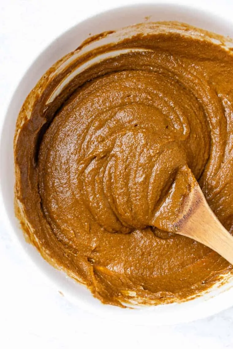 Overhead view of gingerbread cake batter in bowl with spoon