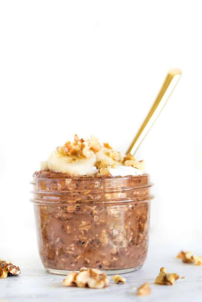 Chocolate overnight oats are an easy breakfast that tastes like dessert! These chocolate oats are vegan, gluten-free, and great for meal prep. Chocolate overnight oats in a small glass jar with a spoon.