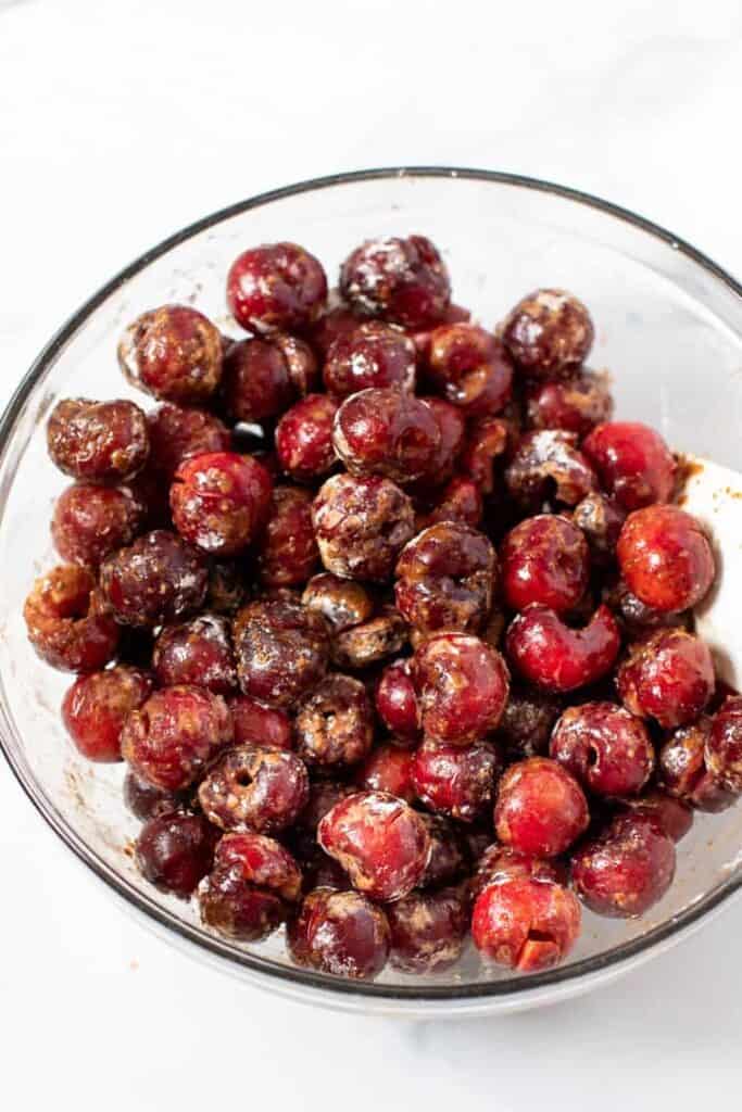 This cherry crumble recipe is an easy summer dessert that's fresh, bright, and juicy underneath a buttery oat crumble. Gluten-free and vegan! Cherry filling in a bowl.